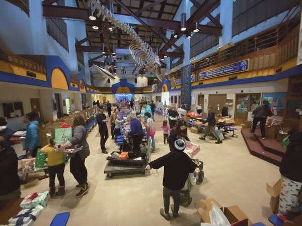 More than 90 community volunteers help pack food and gift baskets for households in need as part of the annual Share the Spirit holiday donation drive on Wednesday, Dec. 20<ins>, 2023</ins> in the Homer High School commons<ins> in Homer, Alaska</ins>. Working from 9 a.m. to approximately 3 p.m., volunteers packed 273 baskets. This years drive also provided goods and gifts for 300 kids. Photo courtesy of Emmy Olsen-Drye