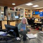 Homer Public Library staff member Teresa Sundmark poses with this years NEA Big Read books, The Cold Millions and The Big Both Ways. Photo provided by Homer Public Library