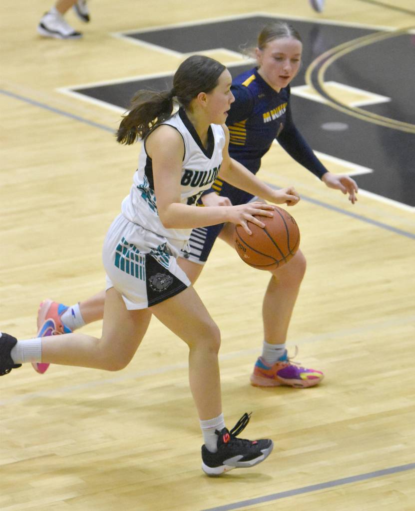 Nikiskis Maggie Grenier dribbles against Homers Channing Lowney on Friday, Jan. 12, 2024, at Nikiski Middle-High School in Nikiski, Alaska. (Photo by Jeff Helminiak/Peninsula Clarion)