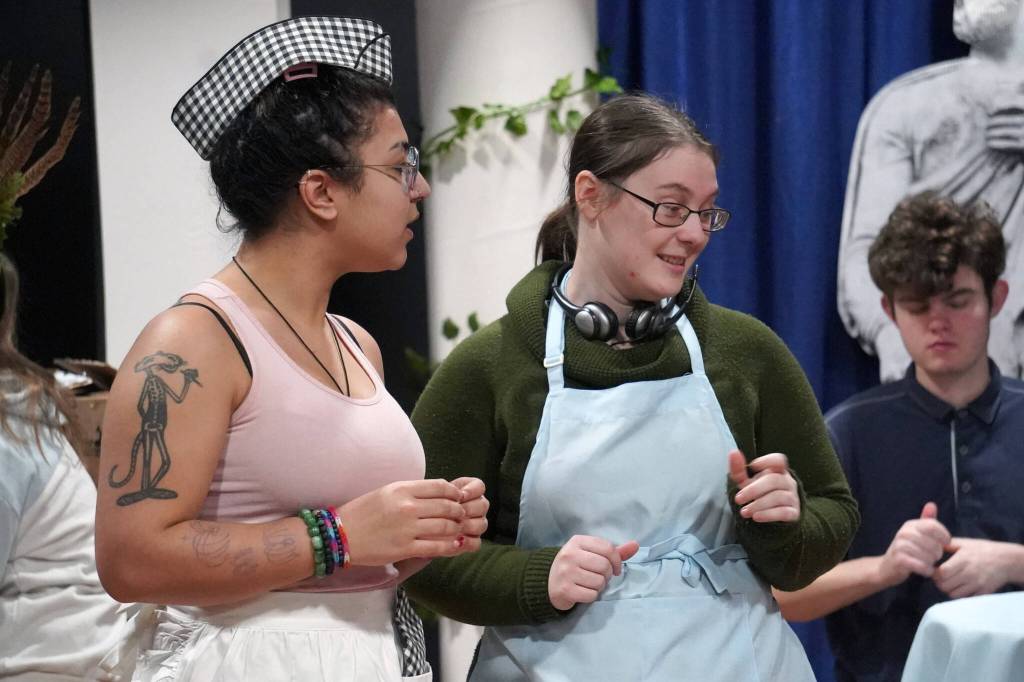 Kassándra Feltman portrays Pandora and Heather Prisk portrays Cassandra during a rehearsal of Greece is the Word: The Zeusical at the Kenai Performers Theatre in Soldotna, Alaska, on Saturday, Jan. 6, 2024. (Jake Dye/Peninsula Clarion)