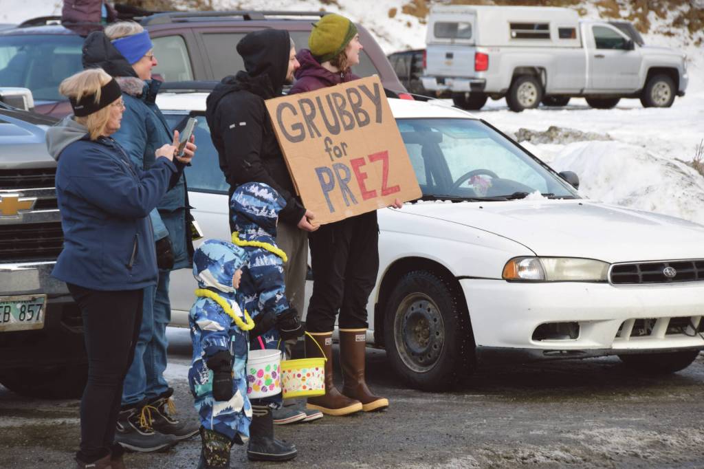 Spectators hold a Grubby for Prez sign, referring to Homers beloved Grubby the Virginia opossum, at the 70th annual Homer Winter Carnival Parade on Pioneer Avenue on Saturday.