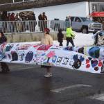 Members of the Alaska Japanese Club carry a banner ahead of their groups float at the 70th annual Homer Winter Carnival Parade on Pioneer Avenue on Saturday, Feb. 10, 2024 in Homer, Alaska. (Delcenia Cosman/Homer News)