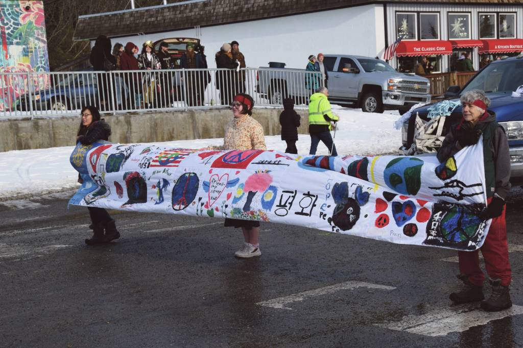 Members of the Alaska Japanese Club carry a banner ahead of their groups float at the 70th annual Homer Winter Carnival Parade on Pioneer Avenue on Saturday, Feb. 10, 2024 in Homer, Alaska. (Delcenia Cosman/Homer News)