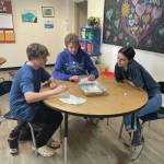 Photo by Emilie Springer
Homer Middle School students Hunter Gauthier, Fletcher Darr and Amakah Stineff conduct the oil spill in a pan experiment in Ms. Boozs 8th grade science class on Feb. 22.