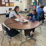 Homer Middle School students Abby Ostrom and Migra Kalafut conduct the oil spill in a pan experiment in Ms. Boozs 8th grade science class on Feb. 22. Photo by Emilie Springer.