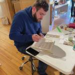 Mitchell Hedrick begins to add paint to his music-themed plate at Bunnells plate workshop on Saturday, March 2<ins>, 2024</ins> at the Bunnell Street Arts Center gallery in Homer<ins>, Alaska</ins>. (Emilie Springer/Homer News)