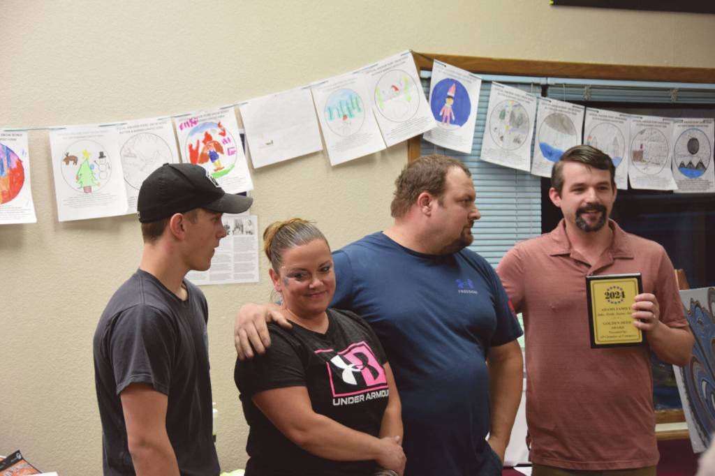 Anchor Point Chamber of Commerce board of directors president Dawson Slaughter presents the Golden Deed Award to the Adams family (pictured from left to right: Zayne Adams, Heidi Adams, Jake Adams. Not pictured: Jaxen Adams) during the Community Awards ceremony on Saturday, March 2, 2024 at the VFW in Anchor Point, Alaska. (Delcenia Cosman/Homer News)