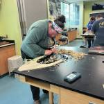 Photo provided by Karyn Murphy
Adrienne McGill shaves down the wood for her hat during the workshop at Islands and Oceans Visitor Center Lab.