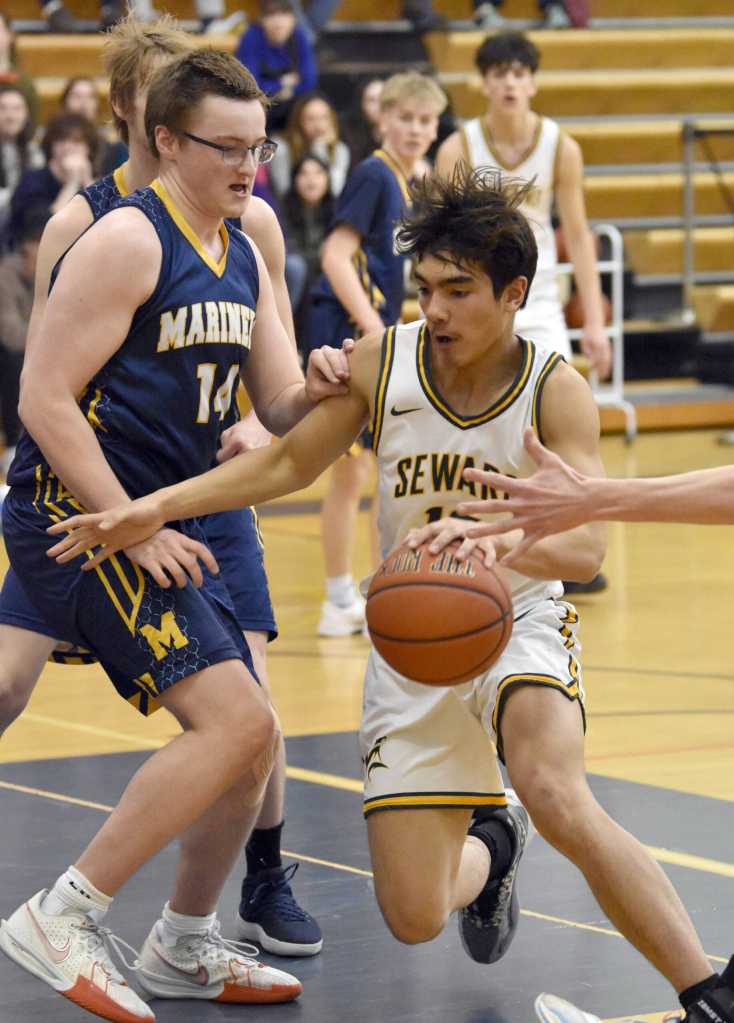 Sewards Nick Ambrosiani drives against Homers Einar Pederson on Saturday, March 9, 2024, at the Peninsula Conference tournament at Homer High School in Homer, Alaska. (Photo by Jeff Helminiak/Peninsula Clarion)