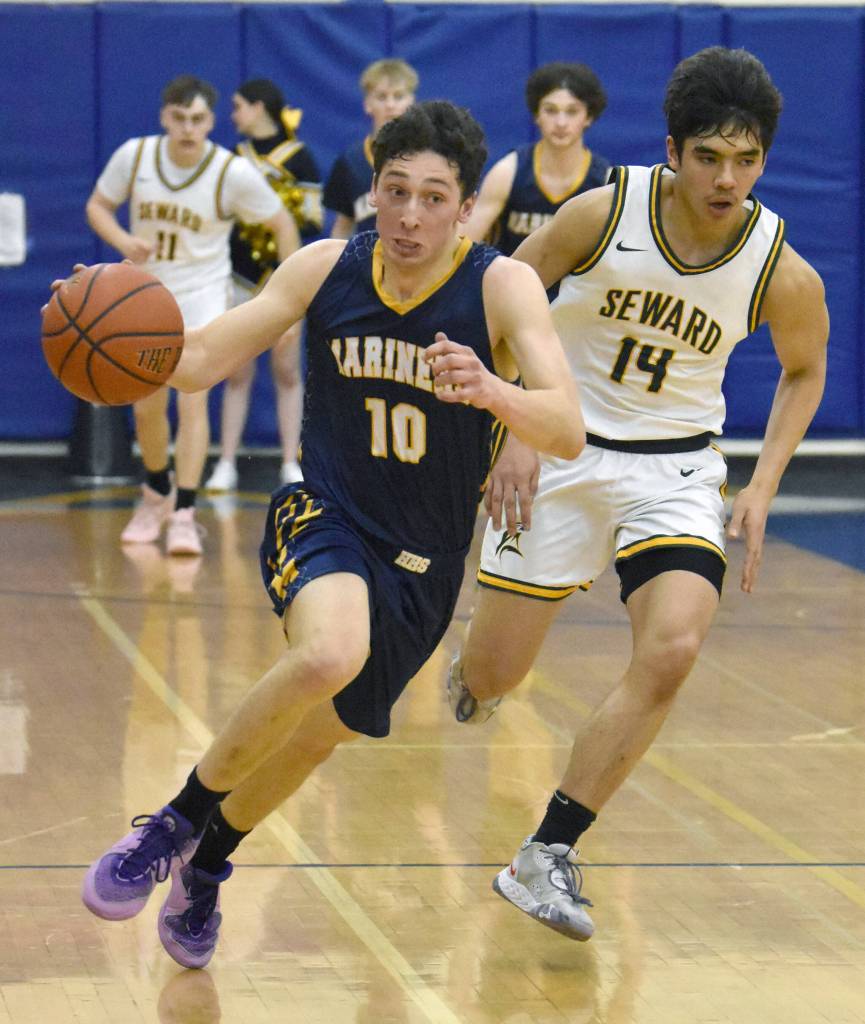 Homers Lucas Story dribbles away from Sewards Ben Ambrosiani on Saturday, March 9, 2024, at the Peninsula Conference tournament at Homer High School in Homer, Alaska. (Photo by Jeff Helminiak/Peninsula Clarion)
