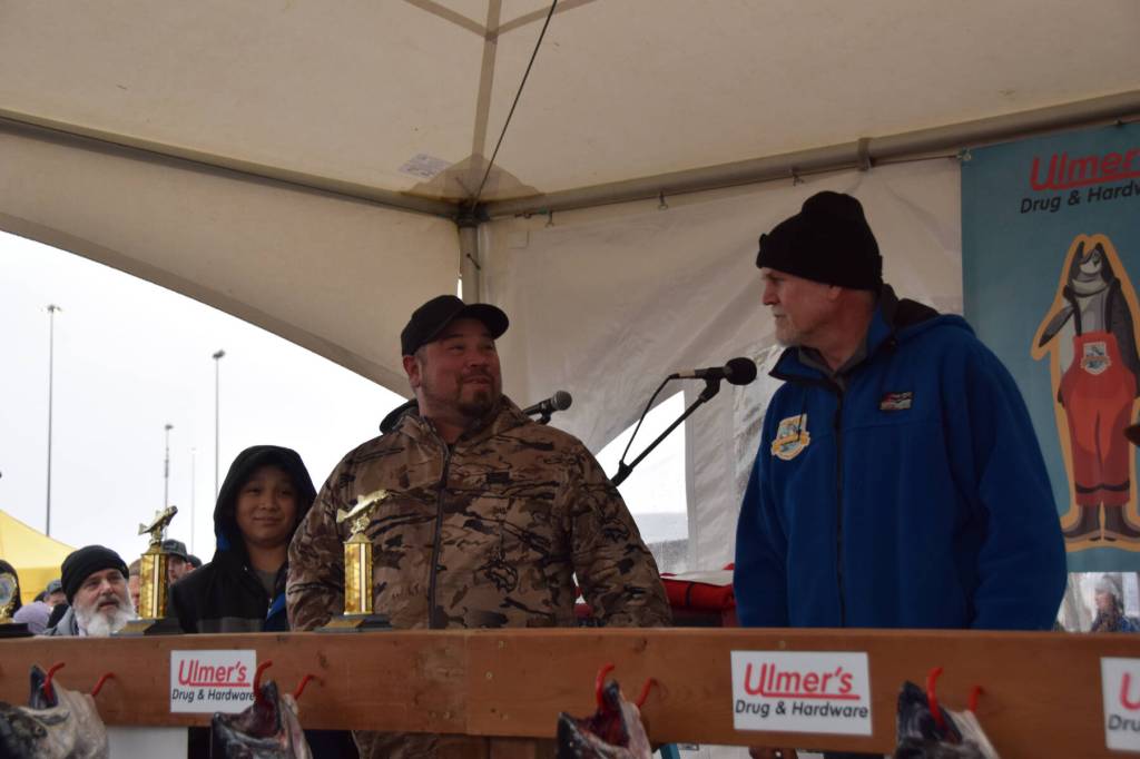 Mike Maxon (center) accepts the sixth place trophy with his son, who was also his fishing partner, at the 30th annual Homer Winter King Salmon Tournament on Saturday, March 23, 2024 at the Deep Water Dock on the Spit in Homer, Alaska. (Delcenia Cosman/Homer News)