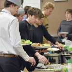 Joel Hanson and Carter McCormick lead the food line Friday, March 29, 2024, at the Soldotna Regional Sports Complex in Soldotna, Alaska. (Photo by Jeff Helminiak/Peninsula Clarion)