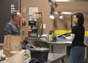 John Bryan and Candace Nakagawa, Co-Directors of Sports Science, Strength and Conditioning, clean up the kitchen after preparing a meal for the Kenai River Brown Bears at the Soldotna Regional Sports Complex in Soldotna, Alaska, on Friday, March 29, 2024. (Photo by Jeff Helminiak/Peninsula Clarion)