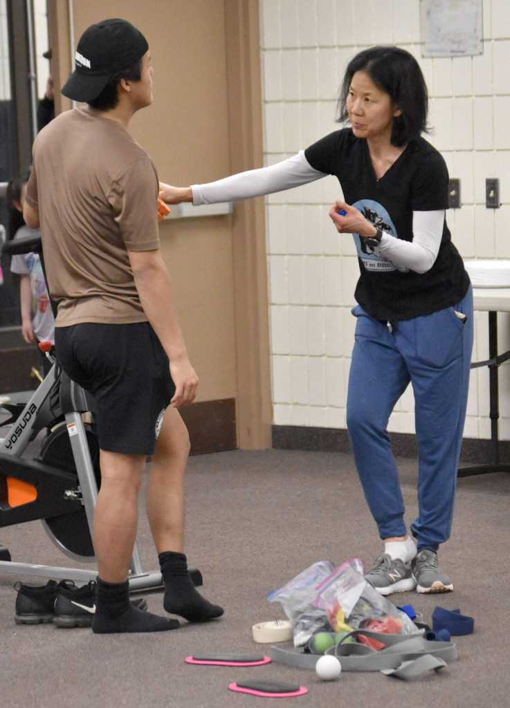 Candace Nakagawa, Co-Director of Sports Science, Strength and Conditioning for the Kenai River Brown Bears, helps Joseph Yoon with a sore foot during a cooldown session after a game at the Soldotna Regional Sports Complex in Soldotna, Alaska, on Friday, March 29, 2024. (Photo by Jeff Helminiak/Peninsula Clarion)
