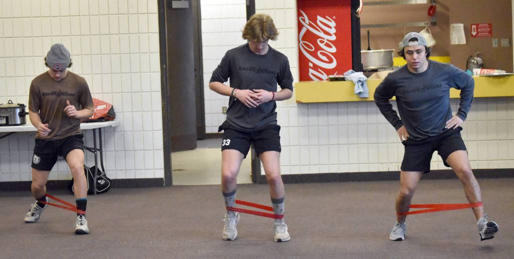 John Ross, AJ Reyelts and Carter Gillen of the Kenai River Brown Bears work out at the Soldotna Regional Sports Complex in Soldotna, Alaska, on Friday, March 29, 2024. The three were scratches for the nights game, but still had to do a full workout before the game. (Photo by Jeff Helminiak/Peninsula Clarion)