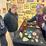 Community members browse art by local youth artists including Rileah and Colin Sims (left), both aged 11, at the Ptarmigan Arts Youth Arts Pop Up on Friday, April 5, 2024 in Homer, Alaska. Photo by Christina Whiting