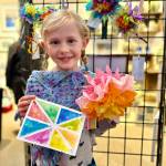 Rosie Mahowald, 7, poses with a watercolor card and paper flower that she made for Ptarmigan Arts Youth Art Pop Up on Friday, April 5, 2024 in Homer, Alaska. Photo by Christina Whiting