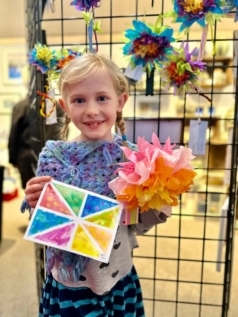 Rosie Mahowald, 7, poses with a watercolor card and paper flower that she made for Ptarmigan Arts Youth Art Pop Up on Friday, April 5, 2024 in Homer, Alaska. Photo by Christina Whiting