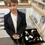 Timmy Christman, 8, shows his wire-wrapped rocks and copper swords during Ptarmigan Arts Youth Art Pop Up on Friday, April 5, 2024 in Homer, Alaska. Photo by Christina Whiting