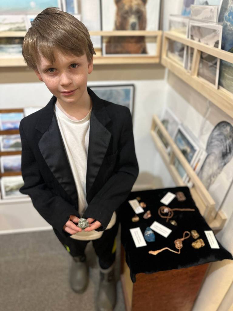 Timmy Christman, 8, shows his wire-wrapped rocks and copper swords during Ptarmigan Arts Youth Art Pop Up on Friday, April 5, 2024 in Homer, Alaska. Photo by Christina Whiting