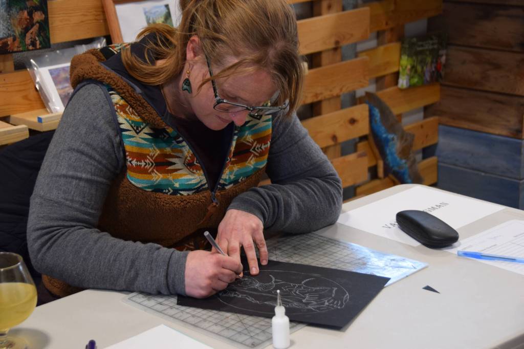 Seldovia artist Valisa Higman crafts one of her famous cut-paper artworks at the Ready, Set, Art! fundraiser, benefiting the Ptarmigan Arts Visual Arts Scholarship Fund, on Saturday, April 13, 2024 at Grace Ridge Brewery in Homer, Alaska. (Delcenia Cosman/Homer News)