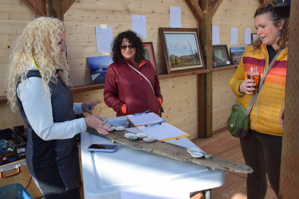 Ceramicist Krista Etzwiler chats with fundraiser attendees as she assembles a wall hanging from clay pinch pots and reclaime driftwood at the Ready, Set, Art! fundraiser, benefiting the Ptarmigan Arts Visual Arts Scholarship Fund, on Saturday, April 13, 2024 at Grace Ridge Brewery in Homer, Alaska. (Delcenia Cosman/Homer News)