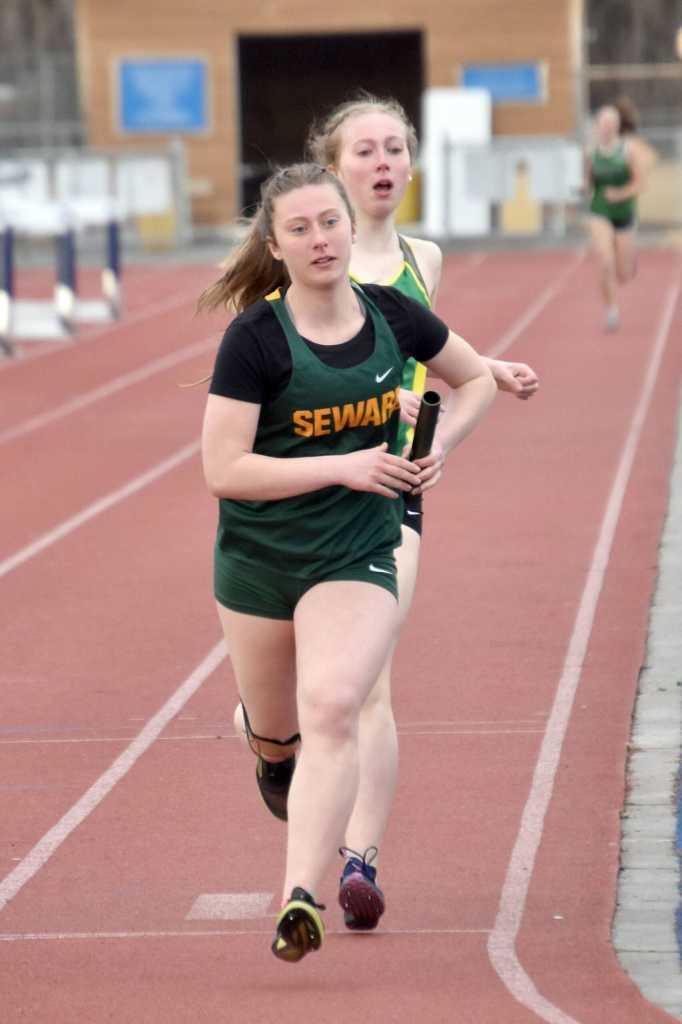 Sewards Juniper Ingalls hands the baton to Hailey Ingalls in the 3,200-meter relay Saturday, April 20, 2024, at the Soldotna Invitational at Soldotna High School in Soldotna, Alaska. (Photo by Jeff Helminiak/Peninsula Clarion)