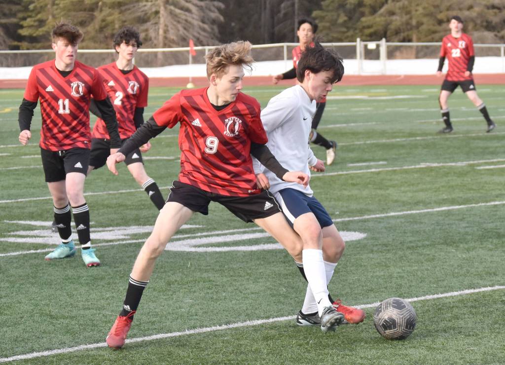 Kenai Centrals Zane James and Homers Reid Rauch battle for the ball Tuesday, April 16, 2024, at Ed Hollier Field at Kenai Central High School in Kenai, Alaska. (Photo by Jeff Helminiak/Peninsula Clarion)