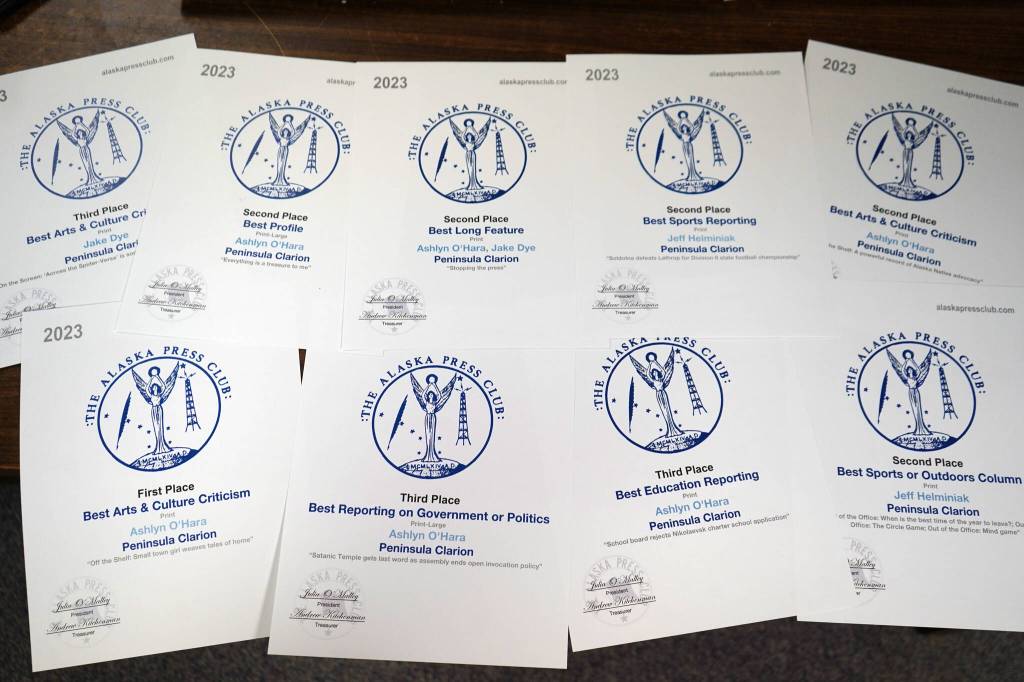 Alaska Press Club awards won by Ashlyn OHara, Jeff Helminiak and Jake Dye are splayed on a desk in the Peninsula Clarions newsroom in Kenai, Alaska, on Monday, April 22, 2024. (Jake Dye/Peninsula Clarion)