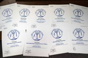 Alaska Press Club awards won by Ashlyn OHara, Jeff Helminiak and Jake Dye are splayed on a desk in the Peninsula Clarions newsroom in Kenai, Alaska, on Monday, April 22, 2024. (Jake Dye/Peninsula Clarion)