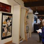 Community members gather at the Pratt Museum on Friday, May 3, 2024 to view art and items donated to Homer by Teshio, Japan, including ceremonial katana, a Hagoita ceremonial racquet, a pair of geta, or traditional wooden sandals, and an Ukiyoe wall hanging depicting kabuki performers, pictured here during the sister city 40th anniversary celebration in Homer, Alaska. (Delcenia Cosman/Homer News)