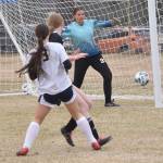 Homers Addi Grimes hits the post in front of Nikiski goalie Emma Weeks on Saturday, May 4, 2024, at Nikiski Middle-High School in Nikiski, Alaska. (Photo by Jeff Helminiak/Peninsula Clarion)