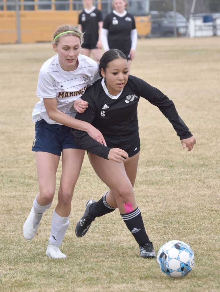 Homers Goldie Hill and Nikiskis Maddie Iyatunguk battle for the ball Saturday, May 4, 2024, at Nikiski Middle-High School in Nikiski, Alaska. (Photo by Jeff Helminiak/Peninsula Clarion)
