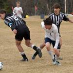Homers Reid Rauch dribbles against Nikiskis Seth Payne and Gavin Carmody on Saturday, May 4, 2024, at Nikiski Middle-High School in Nikiski, Alaska. (Photo by Jeff Helminiak/Peninsula Clarion)