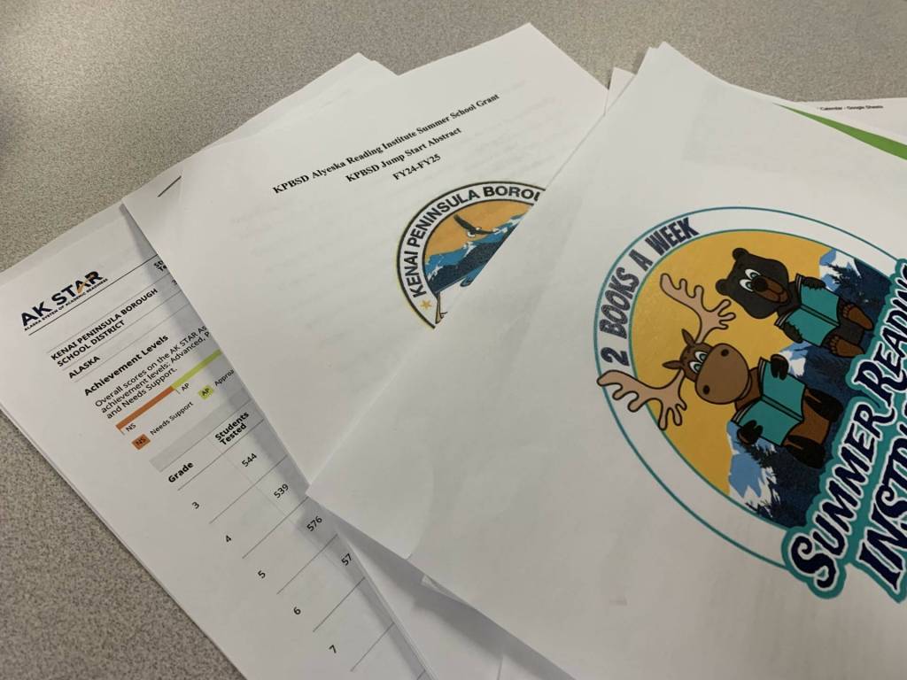 The Kenai Peninsula Borough School Districts grant application for funds to support summer reading programs, along with other reading intervention documents, are displayed on a desk in the Peninsula Clarion offices on Monday, May 13, 2024 in Kenai, Alaska. (Ashlyn OHara/Peninsula Clarion)