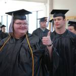 Jake Dye/Peninsula Clarion
A graduate of Kenai Peninsula College gives a thumbs up as graduates proceed into the 54th Annual Kenai Peninsula College Commencement Ceremony at Kenai Central High School on Thursday.