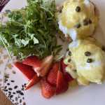 Eggs Benedict are served on homemade English muffins with greens and strawberries. (Photo by Tressa Dale/Peninsula Clarion)