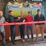 Angry Salmon owners and manager Cameron Johnson, Josh Broda, Chelsea Anderson and Rob Yundt, and Anchor Point Chamber of Commerce president Dawson Slaughter (center) and vice president Erin Jerde (right) conduct a ribbon cutting ceremony for the Angry Salmons grand opening on Saturday, May 11, 2024 in Anchor Point, Alaska. (Delcenia Cosman/Homer News)