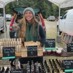 Opening day at the Homer Farmers Market on May 25, Megan Long with Wild Wellness Farm stands in front of her products. Emilie Springer/ Homer News.