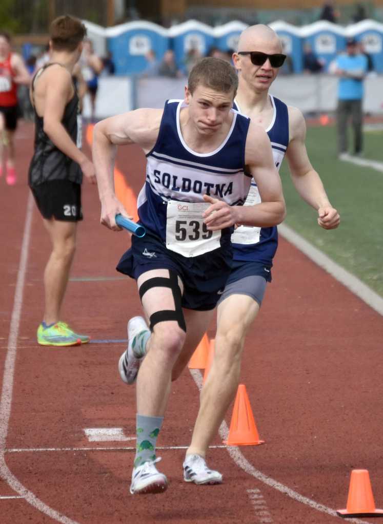 Soldotnas Elijah Jedlicki hands off to James Innes for the final leg of the 3,200-meter relay at the Division I state track and field meet Saturday, May 25, 2024, at Dimond High School in Anchorage, Alaska. The Stars finished second. (Photo by Jeff Helminiak/Peninsula Clarion)