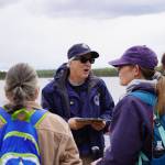 A guide from the Kenai National Wildlife Refuge leads visitors on a hike of Centennial Trail that concluded at Headquarters Lake near Soldotna, Alaska, on Saturday, June 1, 2024. (Jake Dye/Peninsula Clarion)