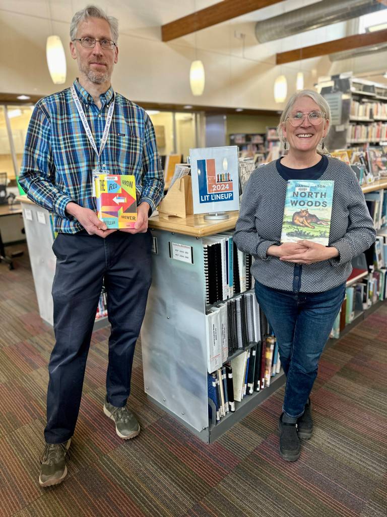 Homer Public Library staff and Lit Lineup organizers Matthew Smith (left) and Teresa Sundmark (right) pose with book selections at the library on April 17, 2024, in Homer, Alaska. Photo by Christina Whiting