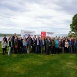 Attendees gather for photos at the ribbon cutting for the Kenai River Bluff Stabilization Project on the bluff above the Kenai River in Kenai, Alaska, on Monday, June 10, 2024. (Jake Dye/Peninsula Clarion)