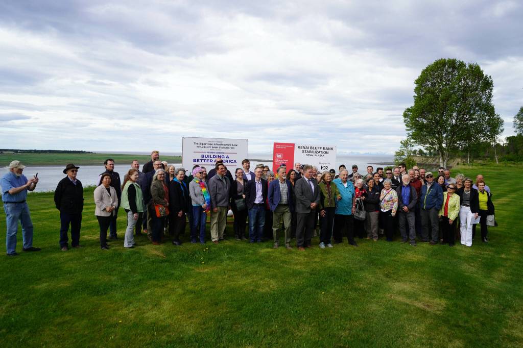 Attendees gather for photos at the ribbon cutting for the Kenai River Bluff Stabilization Project on the bluff above the Kenai River in Kenai, Alaska, on Monday, June 10, 2024. (Jake Dye/Peninsula Clarion)