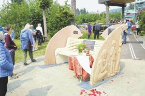 People visit at the Loved & Lost Memorial Bench on Sunday, June 12, 2022, at the Homer Public Library in Homer, Alaska, for a memorial for Anesha Duffy Murnane and the dedication of the bench. (Photo by Michael Armstrong/Homer News)