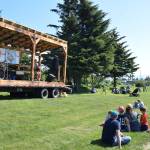 Community members camp out on the grass by Hazel Avenue as Rachel Witman performs on the guitar at the 2nd annual Summer Solstice Fair on Saturday, June 22, 2024, in Homer, Alaska. (Delcenia Cosman/Homer News)