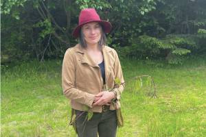 Carla Klinker poses with a long nettle stalk at the Homer News office on Saturday, June 22, 2024 in Homer, Alaska. (Emilie Springer/Homer News)