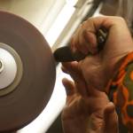 Grey Wilson, of Wilsons Proper Edge, sharpens a knife at Soldotna Creek Park in Soldotna, Alaska, on Wednesday, June 19, 2024. (Jake Dye/Peninsula Clarion)