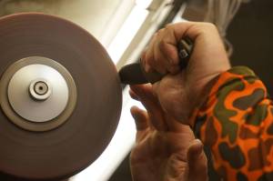 Grey Wilson, of Wilsons Proper Edge, sharpens a knife at Soldotna Creek Park in Soldotna, Alaska, on Wednesday, June 19, 2024. (Jake Dye/Peninsula Clarion)