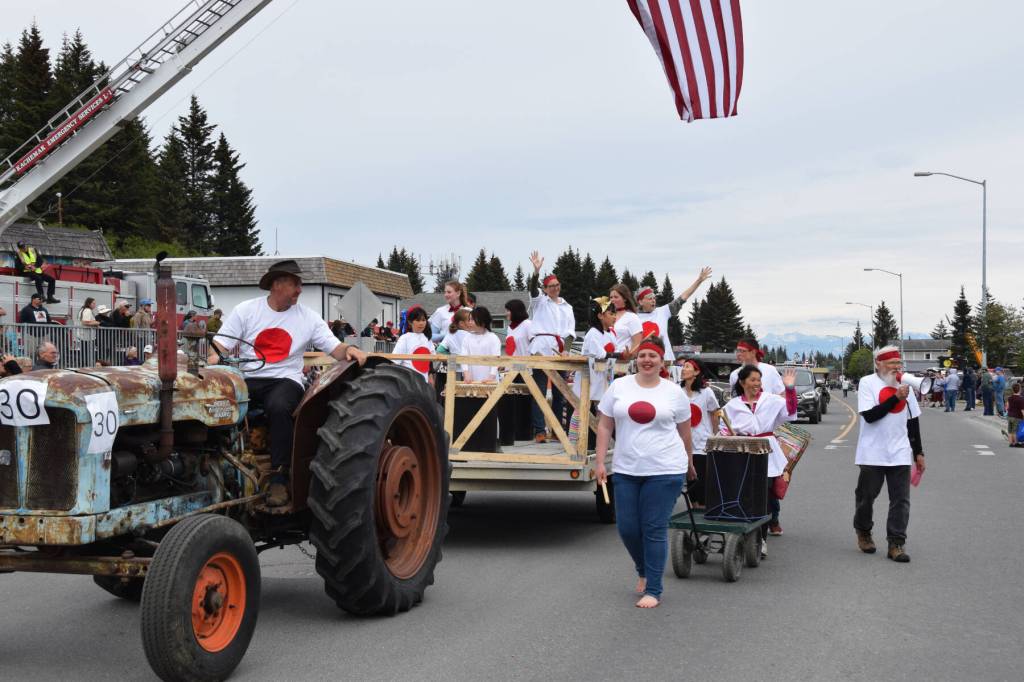 The Alaska Japanese Club, pulled along in their float by a 1961 Diesel Fordson Major tractor which the Anderson family purchased new and has continuously used on their homestead, waves to the crowd along Pioneer Avenue and performs taiko drumming during the Fourth of July parade on Thursday, July 4, 2024, in Homer, Alaska. (Delcenia Cosman/Homer News)